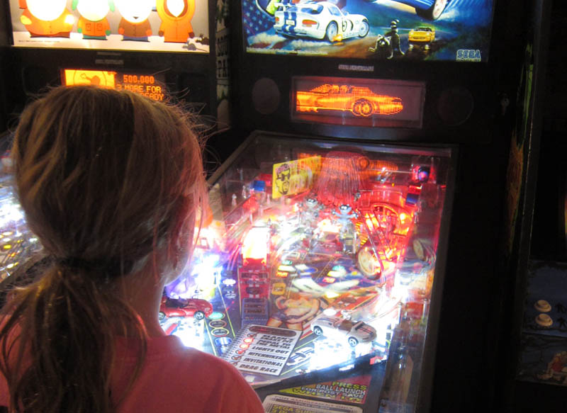 Girl playing pinball